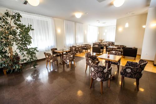 a restaurant with tables and chairs in a room at Hotel Bau Maribor in Maribor