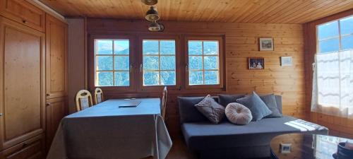 a room with a couch and a table and windows at 2 bedroom chalet with a mountain view in Saint-Jean