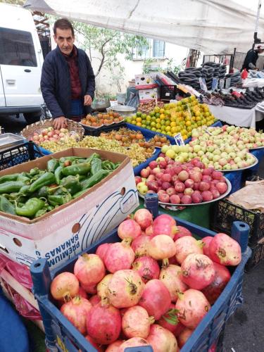 un hombre parado en un mercado de frutas y hortalizas al aire libre en Tarabya Family Suit en Estambul