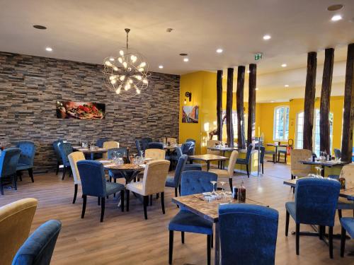 een restaurant met tafels en stoelen en een bakstenen muur bij Castello in Pierrefonds