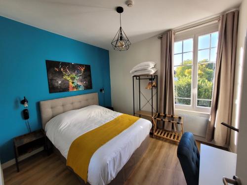 1 dormitorio con cama y pared azul en Castello en Pierrefonds