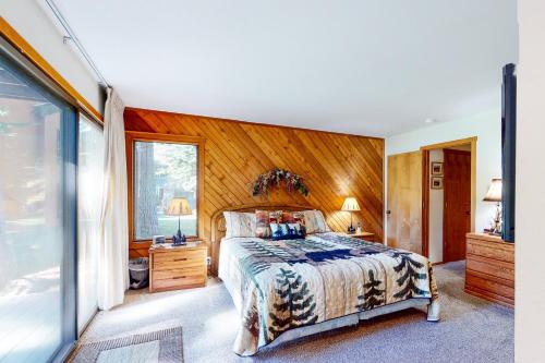 a bedroom with a bed and a wooden wall at Snowcreek 56 in Mammoth Lakes