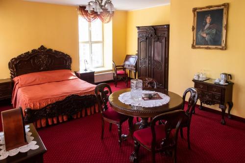 グダニスクにあるドム シュマノフのベッドルーム1室(ベッド1台、テーブル、椅子付)