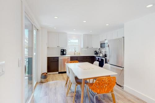 Una cocina con mesa y sillas y un refrigerador. en The Grey Lady, en Provincetown