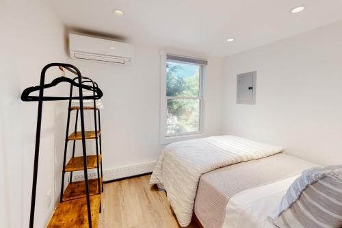 1 dormitorio con cama y escalera junto a una ventana en The Grey Lady, en Provincetown