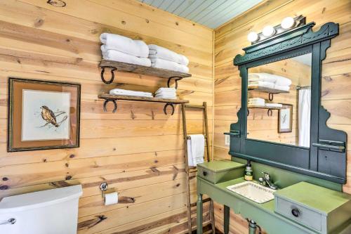 La salle de bains est pourvue de murs en bois, d'un lavabo et d'un miroir. dans l'établissement Lovely Pet-Friendly Flat Rock Cabin from 1905, à Rising Fawn