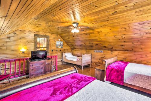 a log cabin bedroom with two beds and a tv at Lovely Flat Rock Cabin from 1905 with Fireplace in Rising Fawn