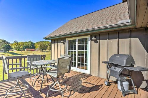a patio with a grill and chairs on a deck at Lovely Flat Rock Cabin from 1905 with Fireplace in Rising Fawn