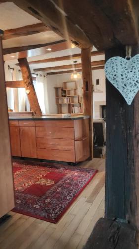 a living room with a wooden dresser and a rug at GITE AU PETIT RUISSEAU-Etage et combles-maison alsacienne 4 personnes 4 nuitées minimum in Langensoultzbach