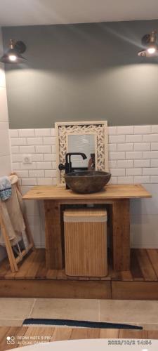 a sink on a wooden table with a mirror at GITE AU PETIT RUISSEAU-Etage et combles-maison alsacienne 4 personnes 4 nuitées minimum in Langensoultzbach