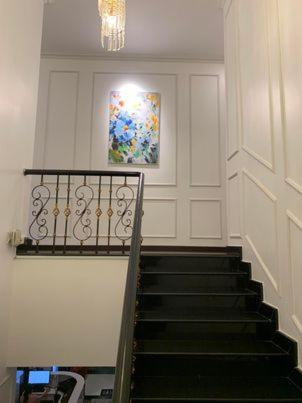 a staircase in a building with a painting on the wall at Hotel My Cang in Trà Vinh