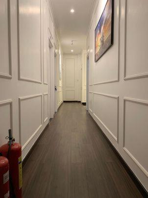 a hallway with white doors and a red fire extinguisher at Hotel My Cang in Trà Vinh
