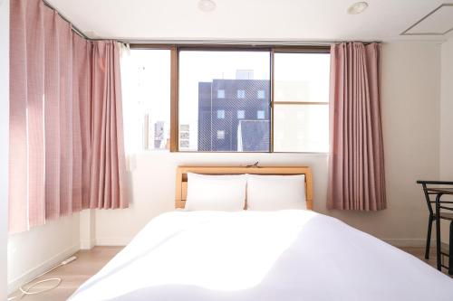 Un dormitorio con una cama y una ventana grande en Shirakabanoyado - Doutonbori 道頓堀, SELF CHECK IN ONLY, en Osaka