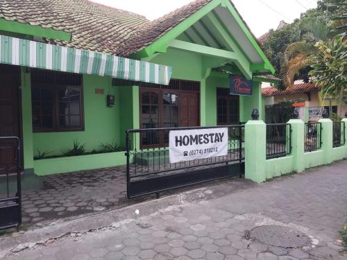 a sign on a fence in front of a house at Omah 365 Homestay in Sentool