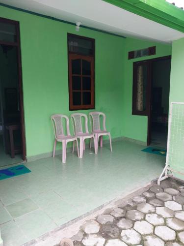 three chairs sitting on the outside of a house at Omah 365 Homestay in Sentool