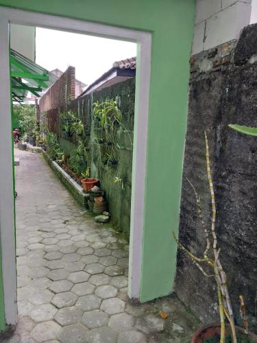 a doorway to a building with a fence and plants at Omah 365 Homestay in Sentool