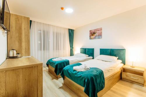 pokój hotelowy z 2 łóżkami i zieloną pościelą w obiekcie Vila Stadion w mieście Kimpulung Mołdawski