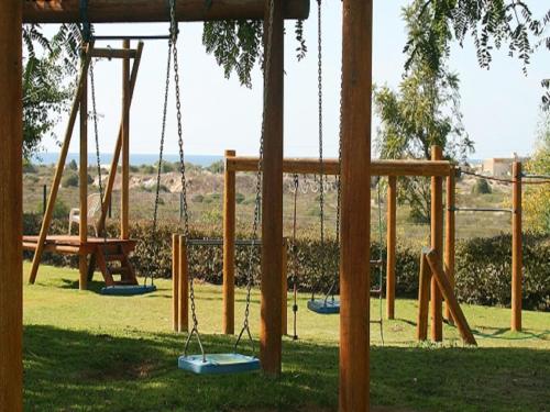 a playground with swings in a park at Caesarea Vacation Rooms in Caesarea