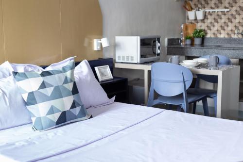 a bedroom with a bed and a kitchen with a microwave at Hive Manila Guesthouse -Netflix,400mbps WI-FI in Bacoor