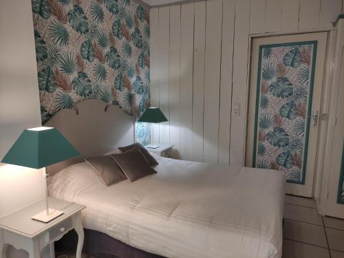 a bedroom with a bed and a table with a lamp at Le Pavillon Saint-Martin in Souillac
