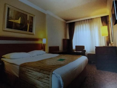 ein Hotelzimmer mit einem großen Bett und einem Fenster in der Unterkunft STAYCITY OTEL in Altındağ