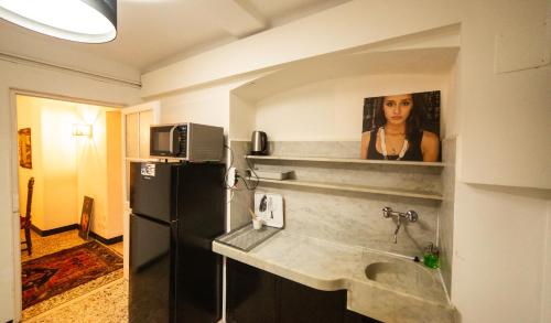 eine Küche mit einer Spüle und einem Kühlschrank in der Unterkunft The Apartment Genova in Genua