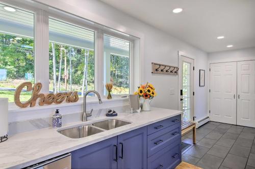 a kitchen with a sink and two windows at Sunny Stockton Springs Home Less Than 1 Mi to Beach! in Stockton Springs