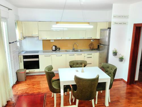 una cucina con tavolo e sedie bianchi di Luxury apartment Podgorica a Podgorica