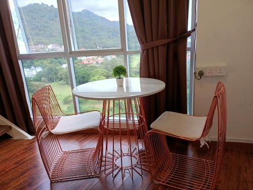 a table and chairs in front of a window at SY Staycation - Studio in Bayan Lepas