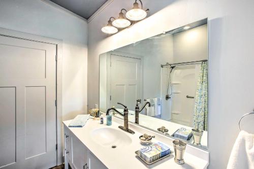 ein Badezimmer mit einem Waschbecken und einem großen Spiegel in der Unterkunft Granvilles Blue Cottage Porch and River View! 