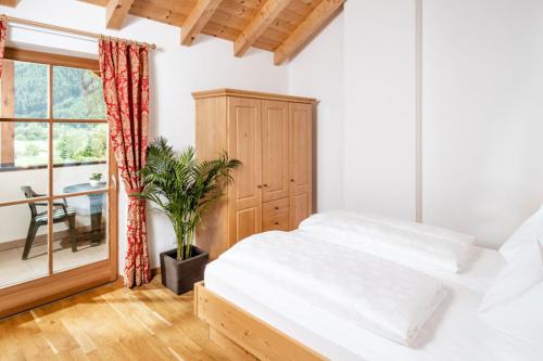 ein Schlafzimmer mit einem weißen Bett und einem Fenster in der Unterkunft Fini's Apartments in Sterzing