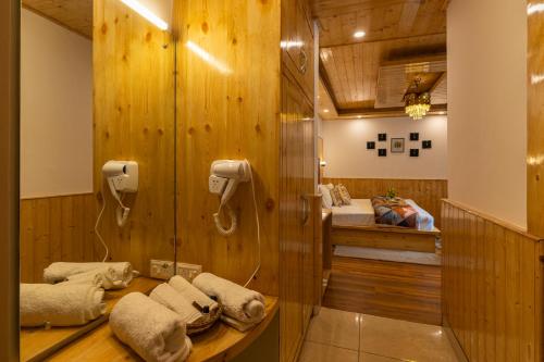 a bathroom with a shower and a bed in a room at The 14 Gables, A Boutique Stay in Manāli