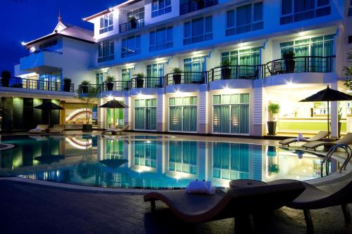 ein Schwimmbad vor einem Gebäude bei Nacht in der Unterkunft A-Te Chumphon Hotel - SHA Plus in Chumphon