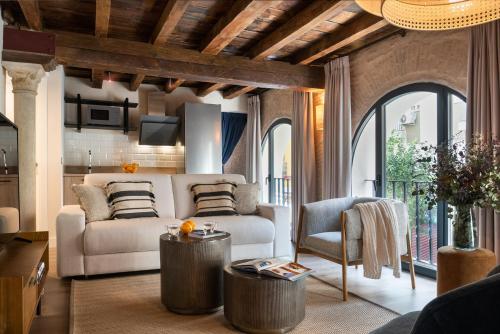 een woonkamer met een bank en een tafel bij La Sillería de Arfe by Magno Apartments in Sevilla