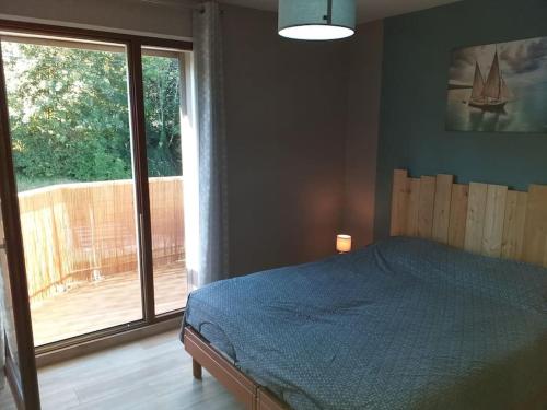 a bedroom with a bed and a large window at Entre Lac et Montagne in Évian-les-Bains