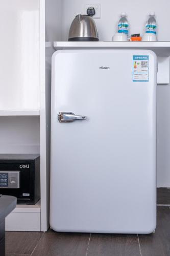 a white refrigerator in a kitchen next to a microwave at Grace Samudera Hotel in Semporna