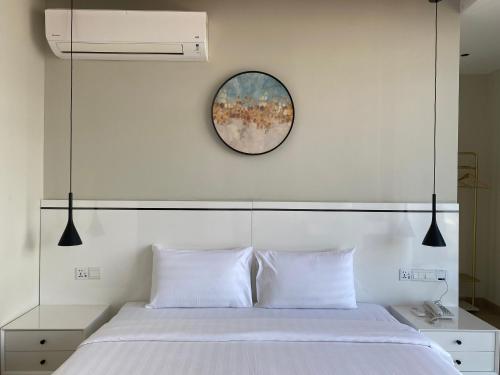 a bedroom with a white bed with a mirror above it at Grace Samudera Hotel in Semporna