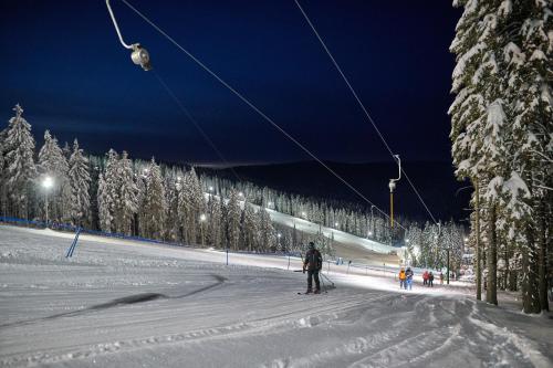 a person is skiing down a snow covered ski slope at Hotel Natura in Zreče