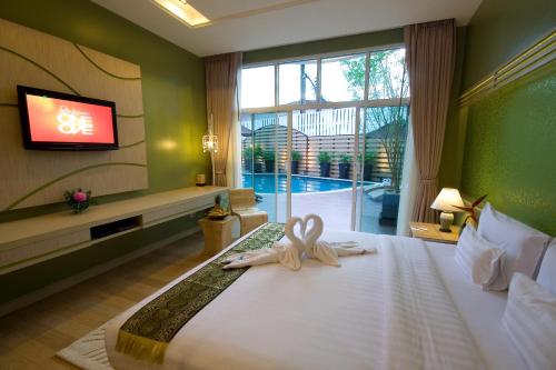 a hotel room with a bed with a ribbon on it at A-Te Chumphon Hotel - SHA Plus in Chumphon
