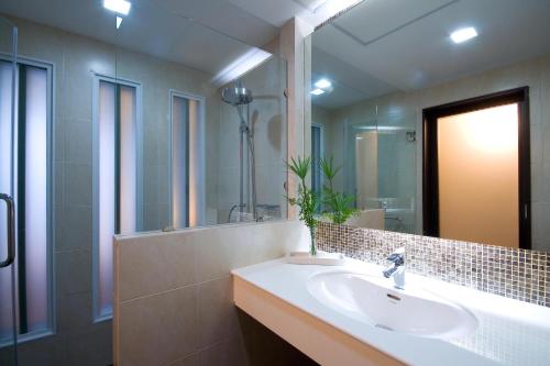 baño con lavabo y espejo grande en A-Te Chumphon Hotel - SHA Plus en Chumphon