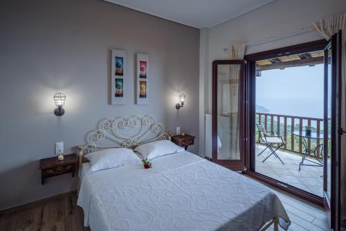 een slaapkamer met een wit bed en een balkon bij Stilvi in Tsagarada