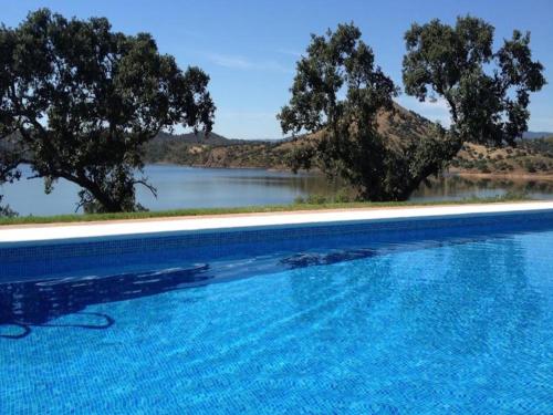 a swimming pool with a view of a body of water at Finca La Vicaria PALOMAR in Zufre