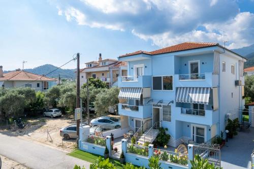 a blue apartment building with a parking lot at Ninemia Studios in Limenas