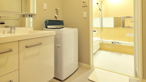 a bathroom with a sink and a refrigerator with a tv on top at RakutenSTAY x Shamaison Osaka Dekijima - 303 in Osaka