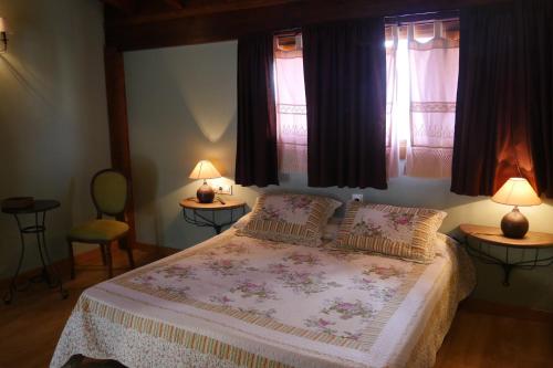 um quarto com uma cama com 2 candeeiros e 2 janelas em Casa Rural Osante em Labastida