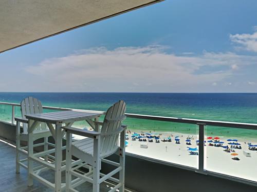 two chairs and a table on a balcony overlooking the beach at Silver Beach #701 Orange Beach in Orange Beach