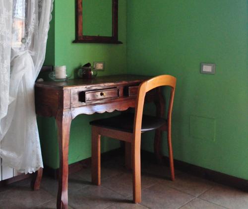 a wooden desk with a chair next to a green wall at Country House Al Faraone in Poggio Picenze