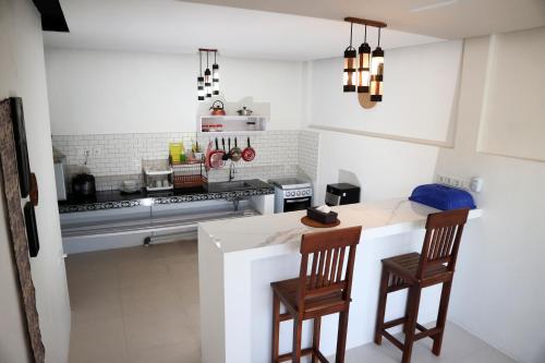 a kitchen with a counter and two chairs and a stove at BALI AMED FEEL HOME VILLA in Amed