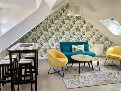 a living room with a blue couch and a table and chairs at Les Mots Bleus in Dinard