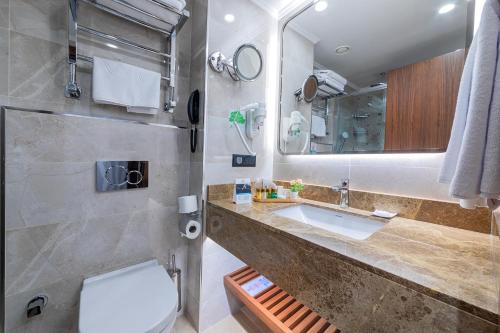 a bathroom with a sink and a toilet and a mirror at Mukarnas Pera Hotel in Istanbul